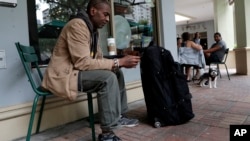 Darnell Metcalf, 55, a regular customer of Starbucks, sits outside of the store after it closed temporarily, May 29, 2018, in Miami.