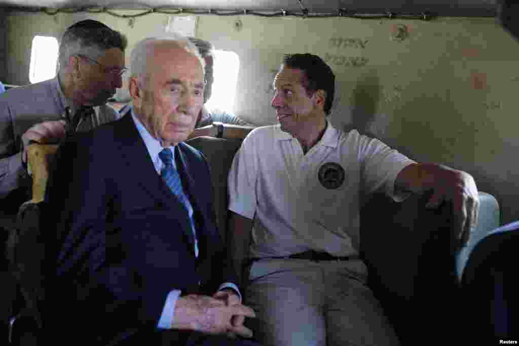Mantan Presiden Israel Shimon Peres (kedua dari kiri) dan Gubernur New York Andrew Cuomo, kanan mengendarai kendaraan lapis baja dalam tur dekat perbatasan dengan Jalur Gaza, 14 Agustus 2014.