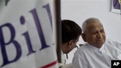 Indian social activist Anna Hazare, right, looks on during his hunger strike against corruption, in New Delhi, India, April 7, 2011