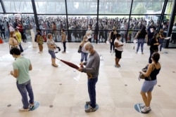 Health care workers line up before receiving the first dose of the Sinovac's CoronaVac coronavirus vaccine in the Positivo event center at the Barigui Park in Curitiba, Brazil, Jan. 28, 2021.