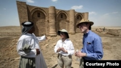 Laurie Rush and colleague Brian Rose at the ancient city of Uruk in Iraq, talking with Mr. Altubi, head of the family that protects the site. (Courtesy Laurie Rush)