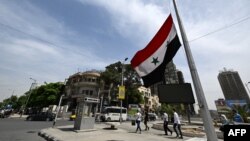 The Syrian flag flies at half-staff in Damascus on May 20, 2024, after the death of Iran's president in a helicopter crash. A car bomb exploded on May 25 in the Damascus neighborhood where the Iranian consulate was located before it was destroyed last month in an aerial attack.