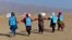 Afghan schoolgirls hold hands and walk towards their tent classrooms on the outskirts of Jalalabad, capital of Nangarhar province, Dec. 13, 2016. 
