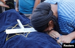 FILE - The mother of Israeli girl, Hallel Yaffa Ariel, 13, who was killed in a Palestinian stabbing attack in her home in the West Bank Jewish settlement of Kiryat Arba, mourns during her daughter's funeral at a cemetery in the West Bank city of Hebron, June 30, 2016.
