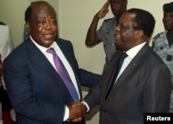 FILE - Charles Konan Banny (L), independent candidate for the 2015 presidential election, shakes hands with Independent Electoral Commission (CEI) President Youssouf Bakayoko (R).