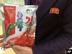 Manager Paek Mi Hye holds a package of kimchi produced at the Ryugyong Kimchi Factory on the outskirts of Pyongyang, North Korea, Dec. 20, 2017. The factory is a showcase of North Korean leader Kim Jong Un’s efforts to boost the country’s domestic economy and produce more, and better, consumer products.