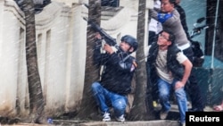 A police officer points his weapon near a government office following an explosion in Bandung, West Java, Indonesia, Feb. 27, 2017.