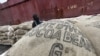 A worker prepares to load sacks of cocoa onto a ship at the port of Abidjan May 8, 2011.