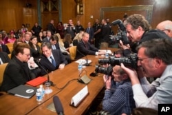 Irish rock star and activist Bono, left, speaks with Deputy Secretary of State Tony Blinken on Capitol Hill in Washington prior to a Senate subcommittee hearing on the causes and consequences of violent extremism, April, 12, 2016.