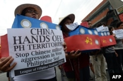 Filipino students hold replicas of Chinese maritime surveillance ships as they shout anti-Chinese slogans during a rally near Malacanang Palace in Manila on March 3, 2016, to denounce reported Chinese vessels dropping anchor near a South China Sea atoll a