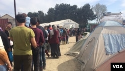 Families wait in long lines for food from aid organizations. Many have now run out of money to purchase their own food in Indomeni, Greece, March 31, 2016. (H. Murdock/VOA)