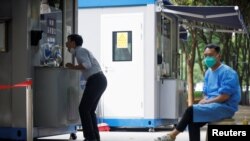 Un ciudadano se somete a la prueba del covid, mientras otro aguarda su turno, tras un nuevo brote de la enfermedad en Beijing, el 13 de septiembre de 2022.