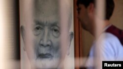 ទេសចរ​មួយ​រូប​មើល​រូបថត​អតីត​មេ​ដឹកនាំ​ខ្មែរ​ក្រហម​ នួន ជា ឬ «បង​ធំ​ទី​២» នៅ​សារមន្ទីរ​ប្រល័យ​ពូជសាសន៍​ទួលស្លែង​នៅ​រាជធានី​ភ្នំពេញ​កាល​ពី​ថ្ងៃ​ទី​២ ខែ​សីហា ឆ្នាំ​២០១៤។