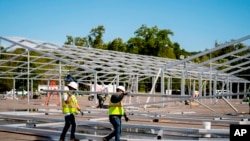 Obreros instalan una gran carpa en la localidad de Orchard Beach, Nueva York, el 27 de septiembre de 2022, para albergar a los migrantes que están llegando a la ciudad.