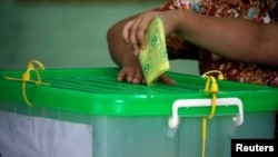 FILE - A voter cast her ballot for the by-election in Yangon, Myanmar, Nov. 3, 2018. 