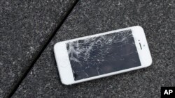 FILE - An Apple iPhone with a cracked screen after a drop test is seen at the offices of SquareTrade in San Francisco.