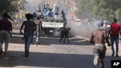 Young men confront the police during a protest against a military coup that ousted a civilian government last month, in Khartoum, Sudan, Nov. 17, 2021. 