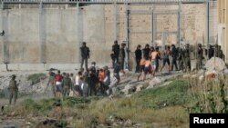 Para remaja dan anak-anak migran yang terdampar di kedua sisi perbatasan Maroko-Spanyol di Ceuta, Spanyol (19/5). 