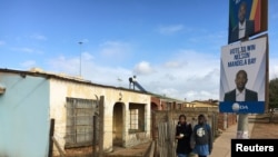 Schoolgirls walk past election posters for the opposition Democratic Alliance (DA) in Port Elizabeth, South Africa, ahead of local government elections, July 29, 2016. 