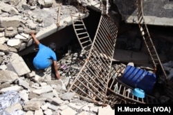 A boy searches for human remains under the rubble of his Old Mosul neighborhood in Mosul, Iraq, May 9, 2018.
