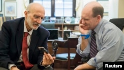 FILE - Former Cuba detainee Alan Gross, left — shown visiting with U.S. Senator Chris Coons of Delaware after his release, on Capitol Hill in Washington, Jan. 13, 2015.
