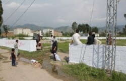 FILE - Pakistani workers mark the edges of the patch of ground where the house where Al-Qaeda leader Osama Bin Laden was killed once stood in Abbottabad on July 23, 2016.