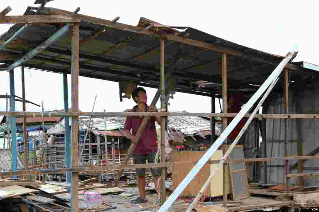 A man dismantles the wall of a floating house in Prek Pra commune, Chbar Ampov district, Phnom Penh, June 12, 2021. (Vicheika Kann/VOA)