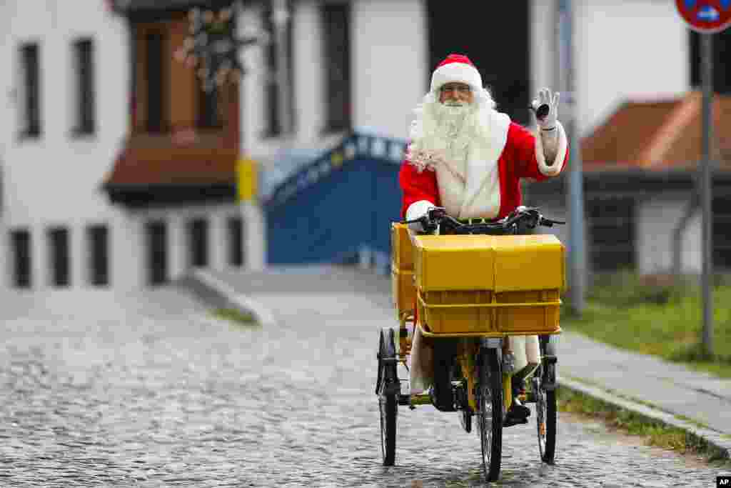 Seorang pria berpakaian sebagai Santa Claus mengendarai sepeda untuk memeriahkan pembukaan kantor surat Natal yang paling terkenal di desa kecil Himmelpfort (yang berarti &#39;Pintu Surga&#39;) di utara Berlin, Jerman.