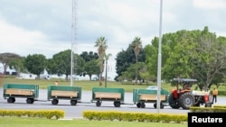 A tractor pulls special airport carts transporting the coffins of the victims of the March 10 Ethiopian Airlines Flight 302 crash from the terminal at the Jomo Kenyatta International Airport in Nairobi, Kenya, Oct. 14, 2019.
