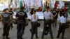 Police officers stand in front of the protesters during an anti-bailout protest outside of the Cyprus parliament in Nicosia, April 30, 2013.