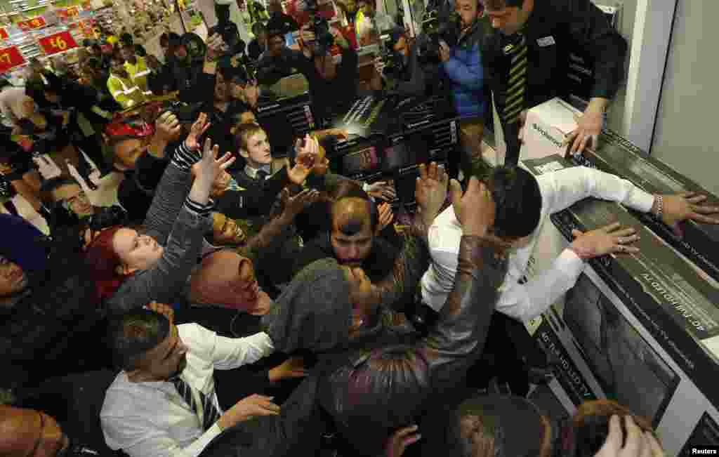 Shoppers compete for items on Black Friday at an Asda superstore in Wembley, north London, Nov. 28, 2014.