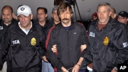 FILE - This Nov. 16, 2010, photo provided by the Drug Enforcement Administration (DEA), shows Russian arms trafficking suspect Viktor Bout, center, led by DEA officers off a flight From Bangkok to New York after his extradition to face terrorism charges.