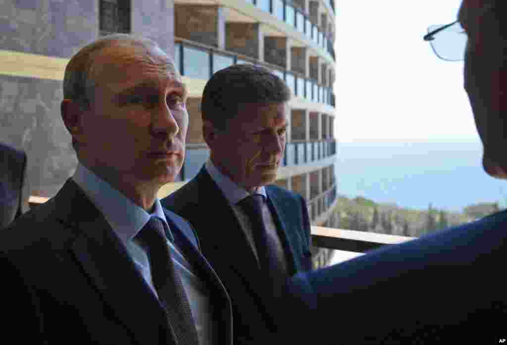 President Vladimir Putin (left) listens to Sberbank President German Gref (right) in Yalta , Crimea, Aug. 14, 2014.