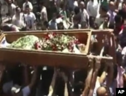Mourners carry the body of a person during a funeral ceremony in the city of Homs, Syria, in this image made from amateur video released by Ugarit News, August 2, 2011
