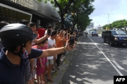 Vietnamese line the street as the motorcade transporting U.S. President Donald Trump passes by, after his arrival for the Asia-Pacific Economic Cooperation (APEC) Summit in Danang, Vietnam, Nov. 10, 2017.