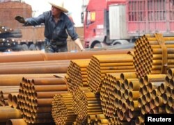 An employee unloads steel products at a market in Yichang, Hubei Province, China, April 11, 2016.