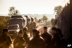 Soldiers and police officers stand beside the border fence between Hungary and Serbia near Roszke, 180 kms southeast from Budapest, Hungary, Sept.14, 2015.