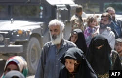 Iraqis leave the Zanjili neighborhood in west Mosul on June 3, 2017, during the ongoing offensive by security forces to retake the city from Islamic State (IS) group fighters.