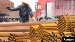 An employee unloads steel products at a market in Yichang, Hubei Province, China, April 11, 2016. The European Commission is conducting three anti-dumping investigations and ‘will undertake other measures if necessary,’ its president said.