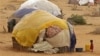 Un enfant devant une hutte dans un camps de réfugiés de Dadaab.