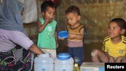 Rohingya children eat from jars with the USAID logo on them, at a refugee camp in Cox's Bazar, Bangladesh, Feb. 11, 2025.