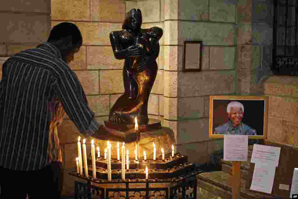 A man places a candle inside the St. George&rsquo;s Cathedral in Cape Town, South Africa, July 17, 2013. 
