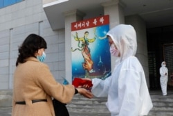 A woman has her temperature checked outside a perfromance for Mother's Day in Pyongyang, North Korea, Nov., 16, 2020.