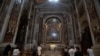 People wearing face masks to prevent the spread of COVID-19 pray in John Paul II chapel in St. Peter's Basilica at the Vatican in the day of its reopening which coincided with John Paul II 100th anniversary of birth, May 18, 2020. 