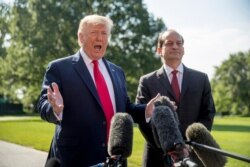 President Donald Trump, accompanied by Labor Secretary Alex Acosta, right, speaks to members of the media on the South Lawn of the White House in Washington, July 12, 2019.