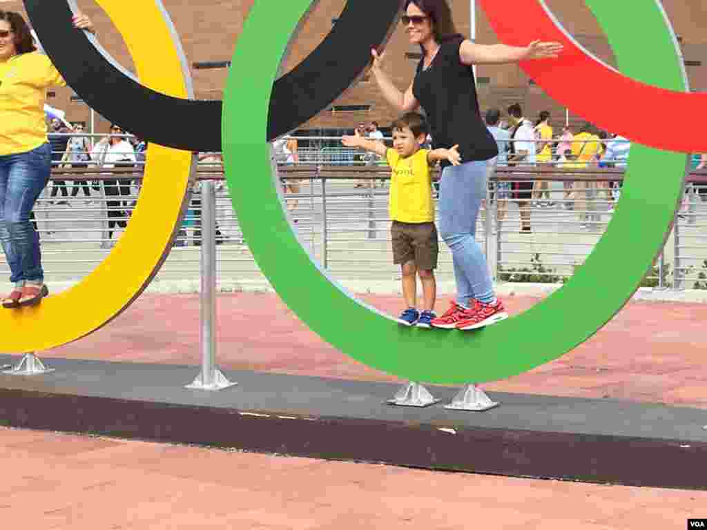 Two fans get their piece of Olympic glory in Rio de Janeiro, Brazil, Aug. 8, 2016. (P. Brewer/VOA)