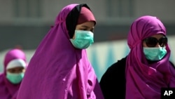 Muslim yang beribadah umrah menggunakan masker wajah untuk mencegah infeksi virus penyakit pernafasan MERS di Mekah, Arab Saudi, Mei 2014.