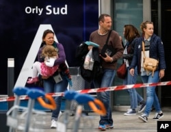 Travelers evacuate Orly airport, south of Paris, March, 18, 2017. Soldiers at Paris' busy Orly Aiport shot and killed a man who wrestled one of their colleagues to the ground and tried to steal her rifle Saturday, officials said.