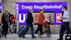 Passengers wear mandatory face masks at the main train station in Essen, Germany, Aug. 24, 2020. 