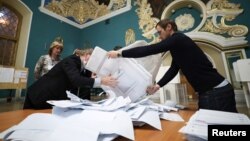 សមាជិក​នៃ​គណៈកម្មការ​រៀបចំ​ការបោះឆ្នោត​ក្នុង​តំបន់ ទម្លាក់​សន្លឹក​ឆ្នោត​ពី​ប្រអប់​បោះឆ្នោត​មួយ មុន​ពេល​ចាប់ផ្តើម​រាប់​សន្លឹកឆ្នោត បន្ទាប់ពី​បិទ​ការបោះឆ្នោត​នៅ​ការិយាល័យ​បោះឆ្នោត​មួយ​នៅខាង​ក្នុង​ស្ថានីយ​រថភ្លើង Kazansky ក្នុង​ទីក្រុង​មូស្គូ នៅ​ថ្ងៃទី១៩ ខែកញ្ញា ឆ្នាំ២០២១។